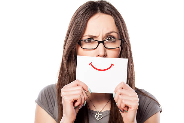 istock Angry young woman with smile painted on paper 534737387