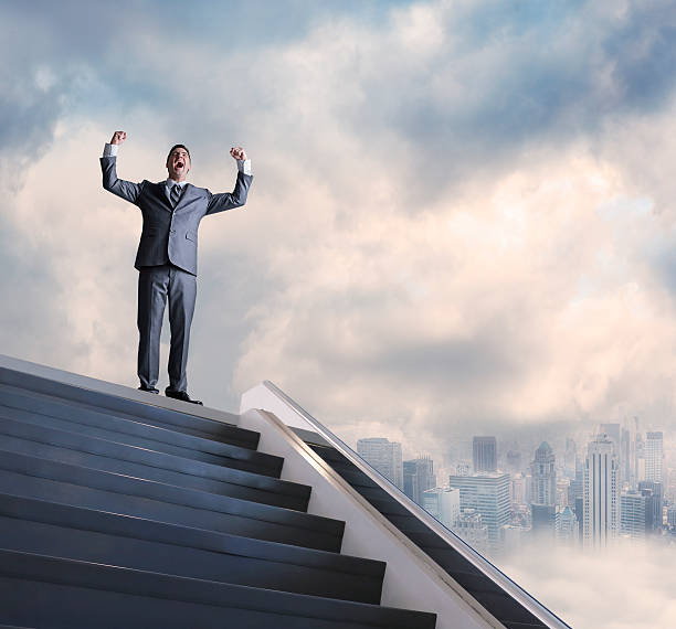 istock Businessman's Arms Raised In Victory At Top Of Stairwell 534738059