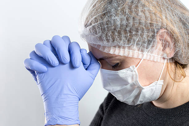 istock Doctor with head in hands sad and praying. Isolated female 534738411