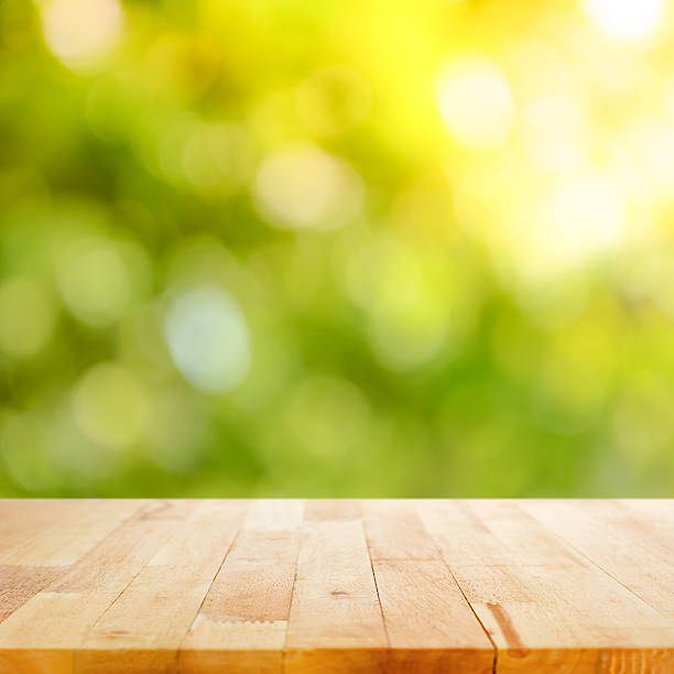 istock Wood table top on bokeh abstract nature green background 534739109