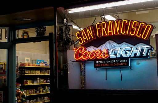 San Francisco, USA - May 29, 2014: Entrance to a small grocery store in San Francisco with neon sign advertising Coors Light beer and baseball team San Francisco Giants.