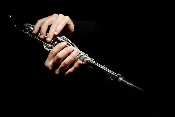 clarinet in the hands of a musician on a black background