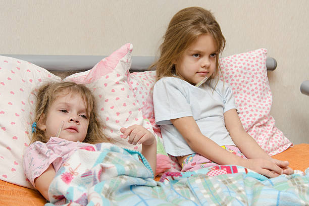 istock Two girls sick meryat temperature 534742827