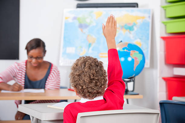 istock Teacher Busy Marking While Student Tries To Get Her Attention 534744829