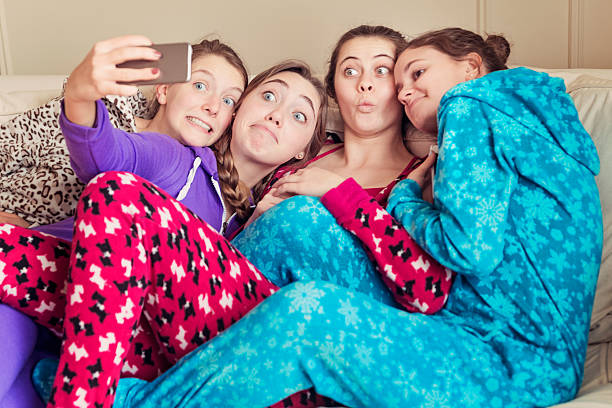 istock Girlfriends wearing onesies making a goofy selfie on a couch. 534745087
