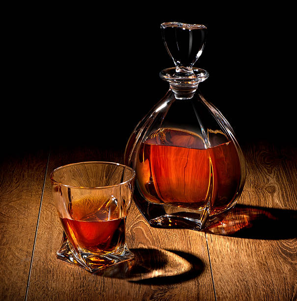 whiskey em preto - brandy bottle alcohol studio shot - fotografias e filmes do acervo