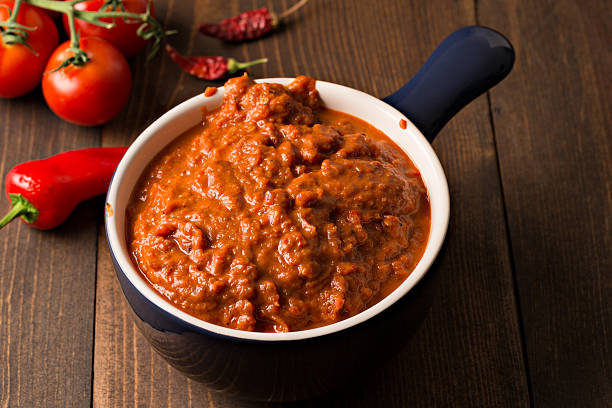 Homemade Harissa Paste A high angle extreme close up, horizontal photograph of a blue bowl containing some homemade Harissa. Harissa is a Maghrebian (Northwest African) hot pepper paste made with roasted red bell peppers, a variety of fresh and dried chili peppers, garlic and tomato paste. solvent stock pictures, royalty-free photos & images