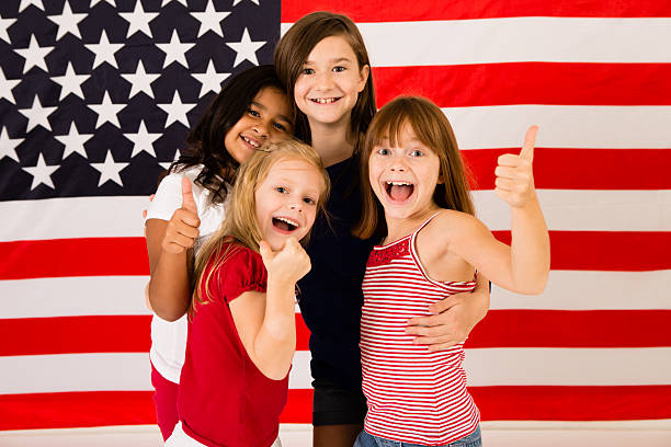 quatro garotas jovem feliz dando polegares para cima da bandeira norte-americana - child flag patriotism thumbs up - fotografias e filmes do acervo