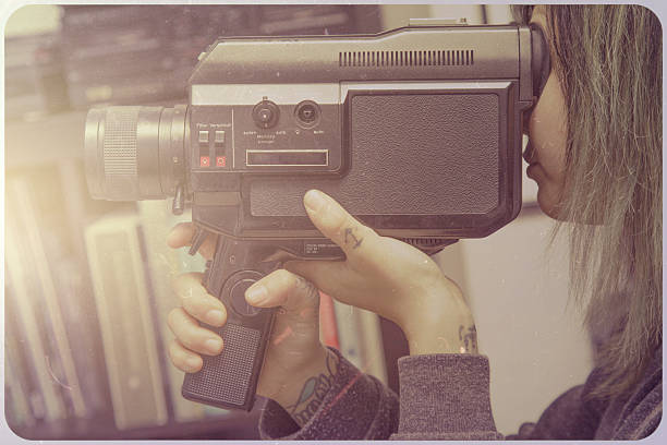 istock Beautiful young woman with video camera 534760599