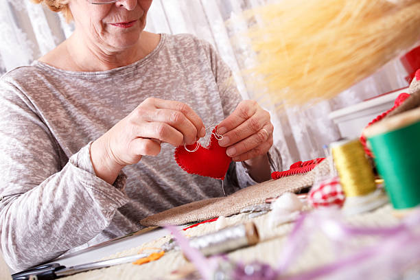 istock Senior women sews by hand 534761167
