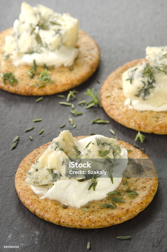 cracker with organic stilton cheese cracker on slate with stilton cheese and thyme 2015 Stock Photo