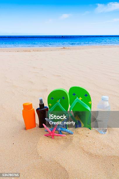 Sandals And Bottle Of Water On Sandy Beach Stock Photo - Download Image Now - 2015, Atlantic Islands, Beach