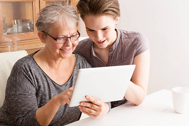 istock young woman explaining tablet pc technology to senior adult fun 534781349