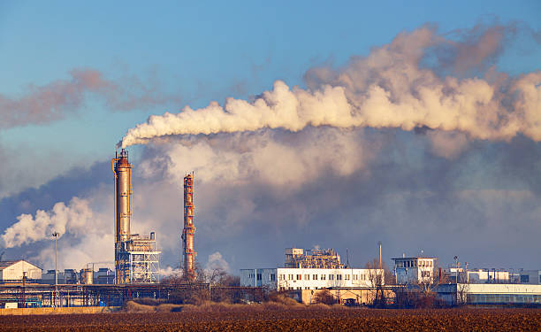 fabrik mit luftverschmutzung - destillationsturm stock-fotos und bilder