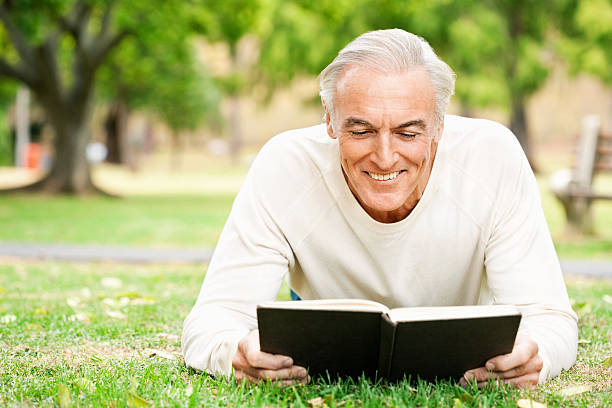 istock Senior Man Reading In The Grass 534781911