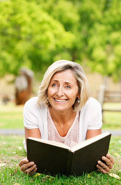 istock Senior Woman Lying In The Grass With A Book 534781951