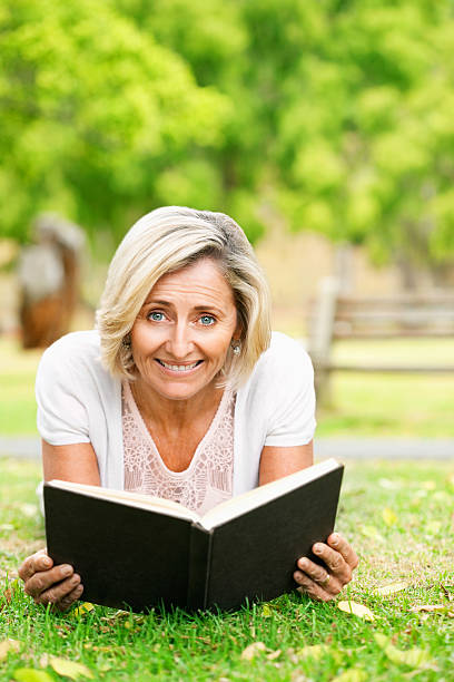 istock Senior Woman Reading In The Grass 534781955