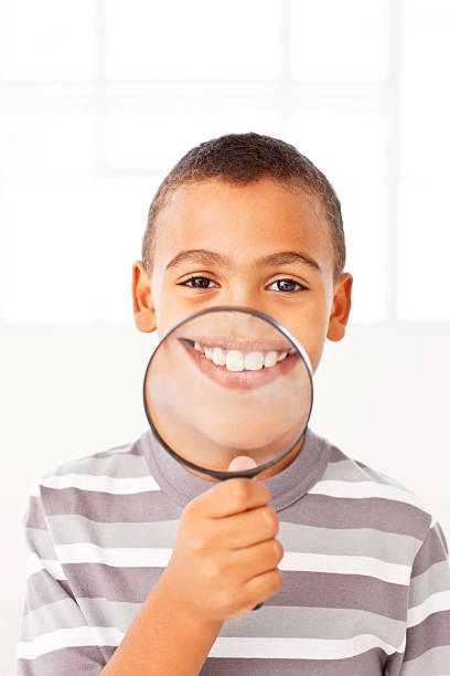 istock Cute African American boy with a magnifying glass 534786641