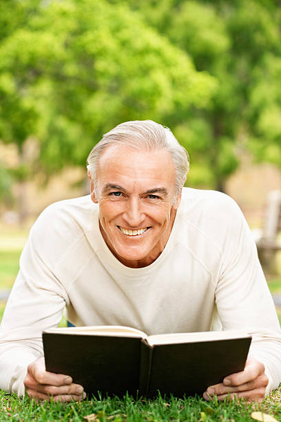 istock Senior Man Reading In The Grass 534788465