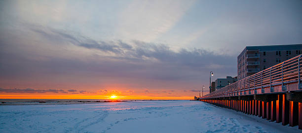 istock Tracks on snowy ground at sunset on Long Beach next to wall. 534798605