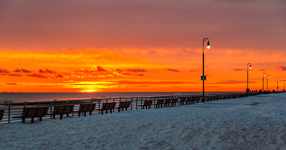The sunset at the Long Beach, Long Island. Winter, cold windy weather, after the snowfall.