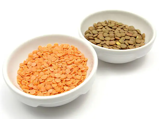 Two bowls of chinaware with lentils and red lentils