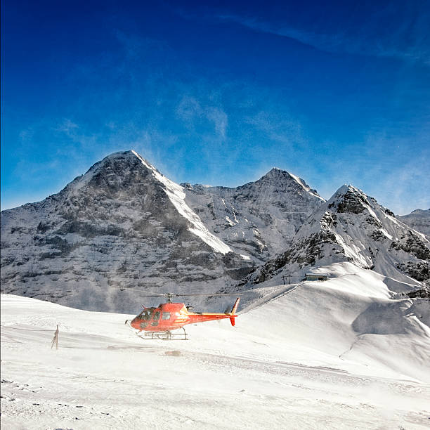 istock Red helicopter raising snow powder at take-off from alpine resor 534824521