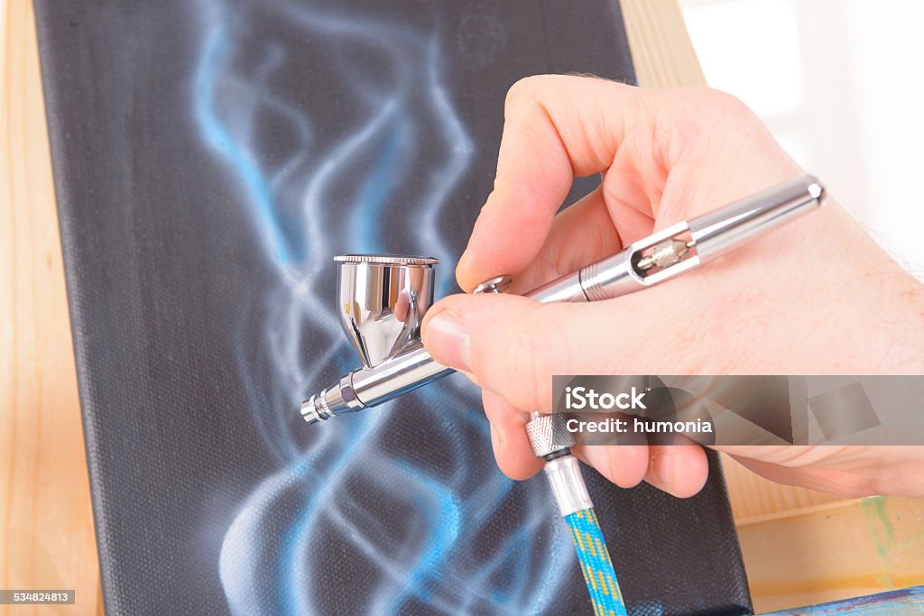 airbrush Hand holding a professional airbrush and painting Airbrush Stock Photo
