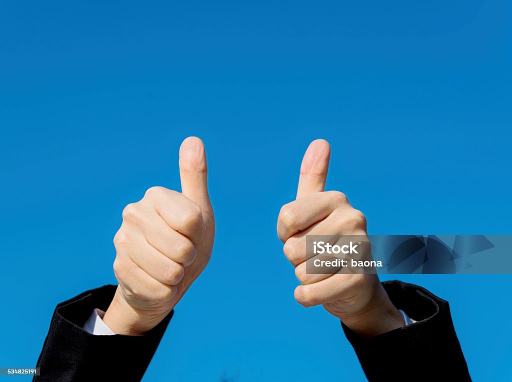 Businesswoman thumbs up Businesswoman thumbs up against clear sky background. 2015 Stock Photo