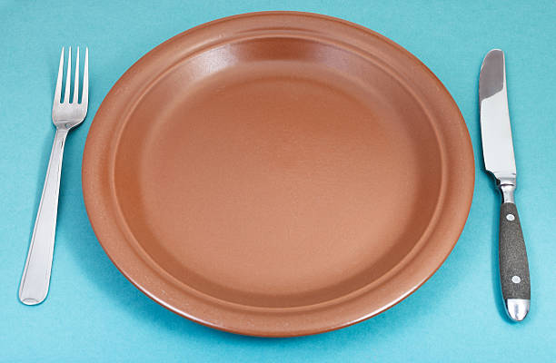 istock brown ceramic plate with fork and knife on green 534826791