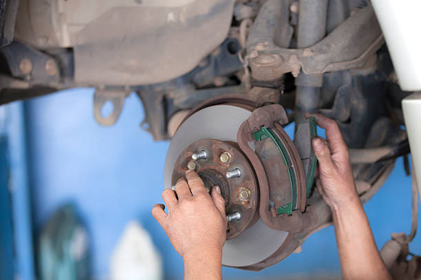 istock bear hands fixing car wheel hub, disc brake 534827789