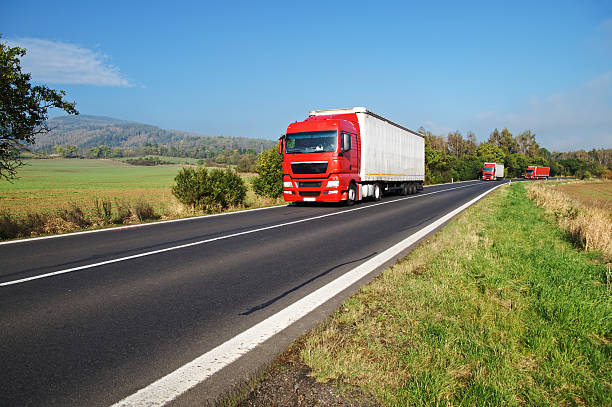 istock Three red trucks on the road in the countryside 534828269