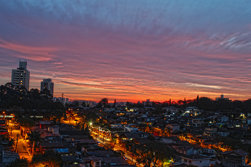 City view of São Paulo at night, green and yellow lights shine between the houses.