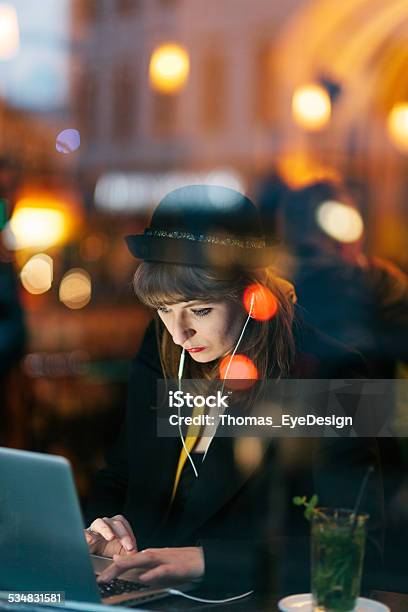 Woman In Cafe Using Technology Stock Photo - Download Image Now - City, Mobile Phone, Night