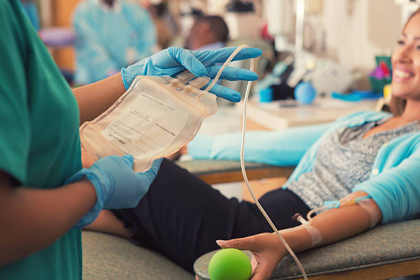 Nurse connecting bag to patient preparing to donate blood