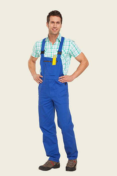 istock Man in overall standing with hand on hip 534843441