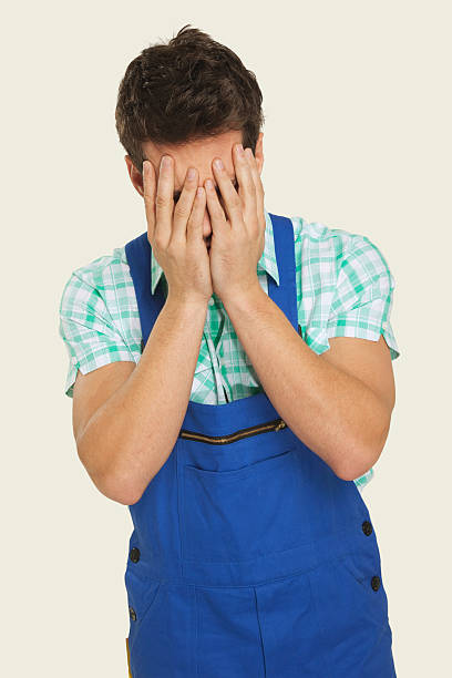istock Man in overall covering face with hands 534843513
