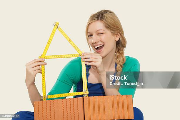 Woman Holding Folding Ruler Winking Stock Photo - Download Image Now - 2015, Activity, Adult