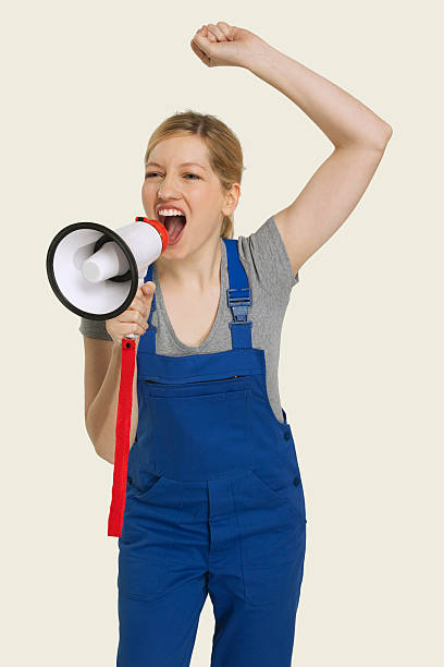 istock Woman in overall shouting through megaphone 534844041