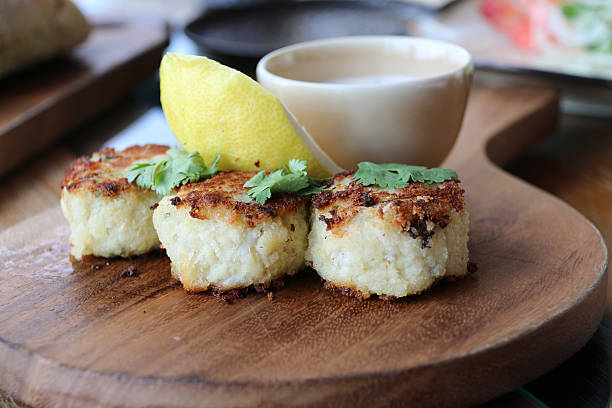 tre mini torte di granchio con salsa rémoulade di e lo spicchio di limone - fish cakes immagine foto e immagini stock