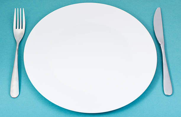 istock white porcelain plate with fork and knife on green 534865627