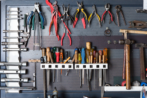mechanic tools hanging on a organized metal board at a vehicle reparation workshop