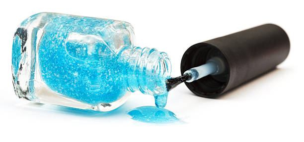 istock bottle and puddle of turquoise nail polish 534869851