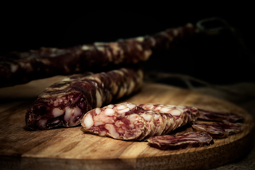 home-made salami on a wooden board. Shallow depth of field