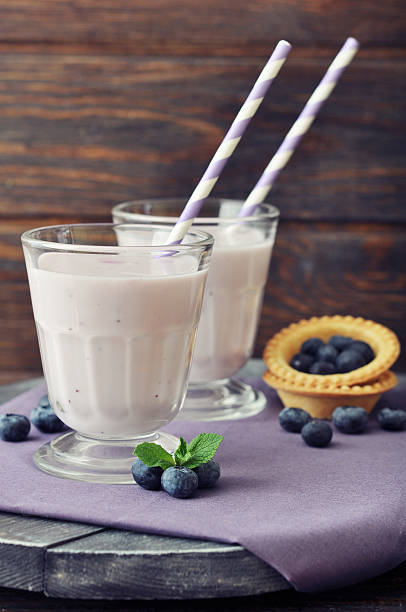 joghurt mit frischen blaubeeren - blueberry smoothie glass striped stock-fotos und bilder