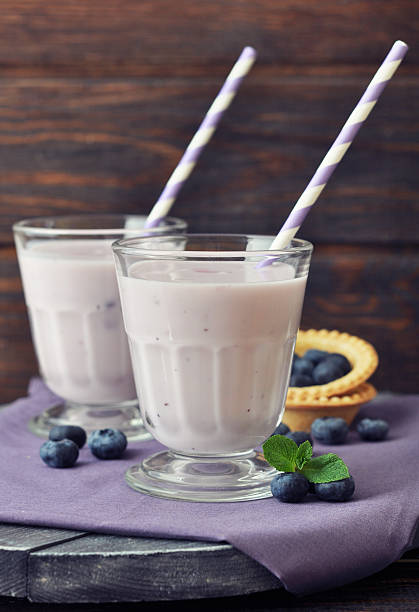 joghurt mit frischen blaubeeren - blueberry smoothie glass striped stock-fotos und bilder