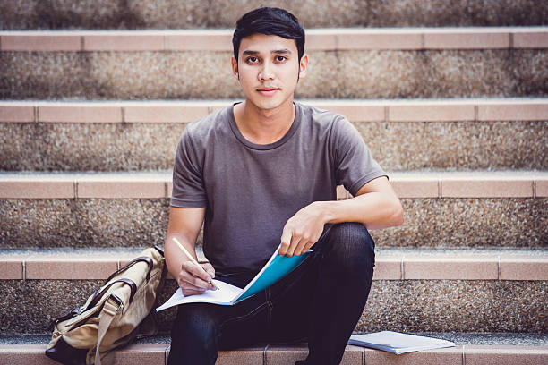 istock Smiling college student sitting on staircase 534880626