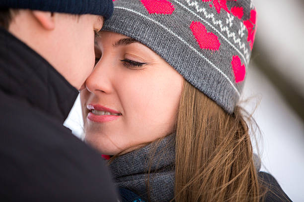 istock loving couple in the winter snow park 534888317