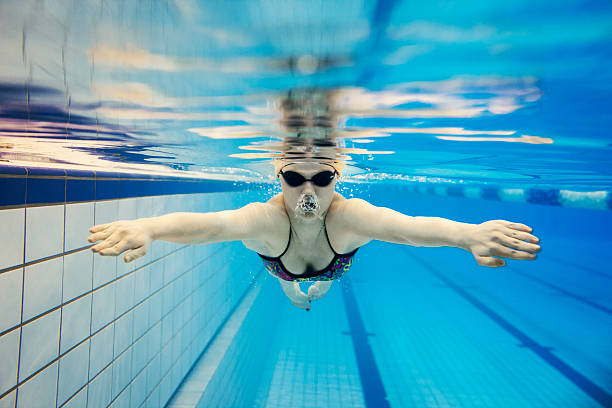 junge frau schwimmen unter wasser - breaststroke stock-fotos und bilder