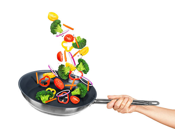 istock Falling vegetables in frying pan on an isolated white background 534888901